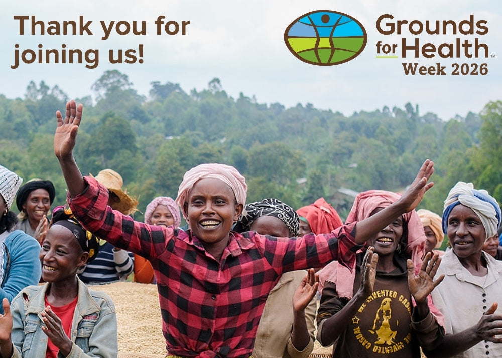 Group of people with raised hands in a field, celebrating Grounds for Health Week 2026.