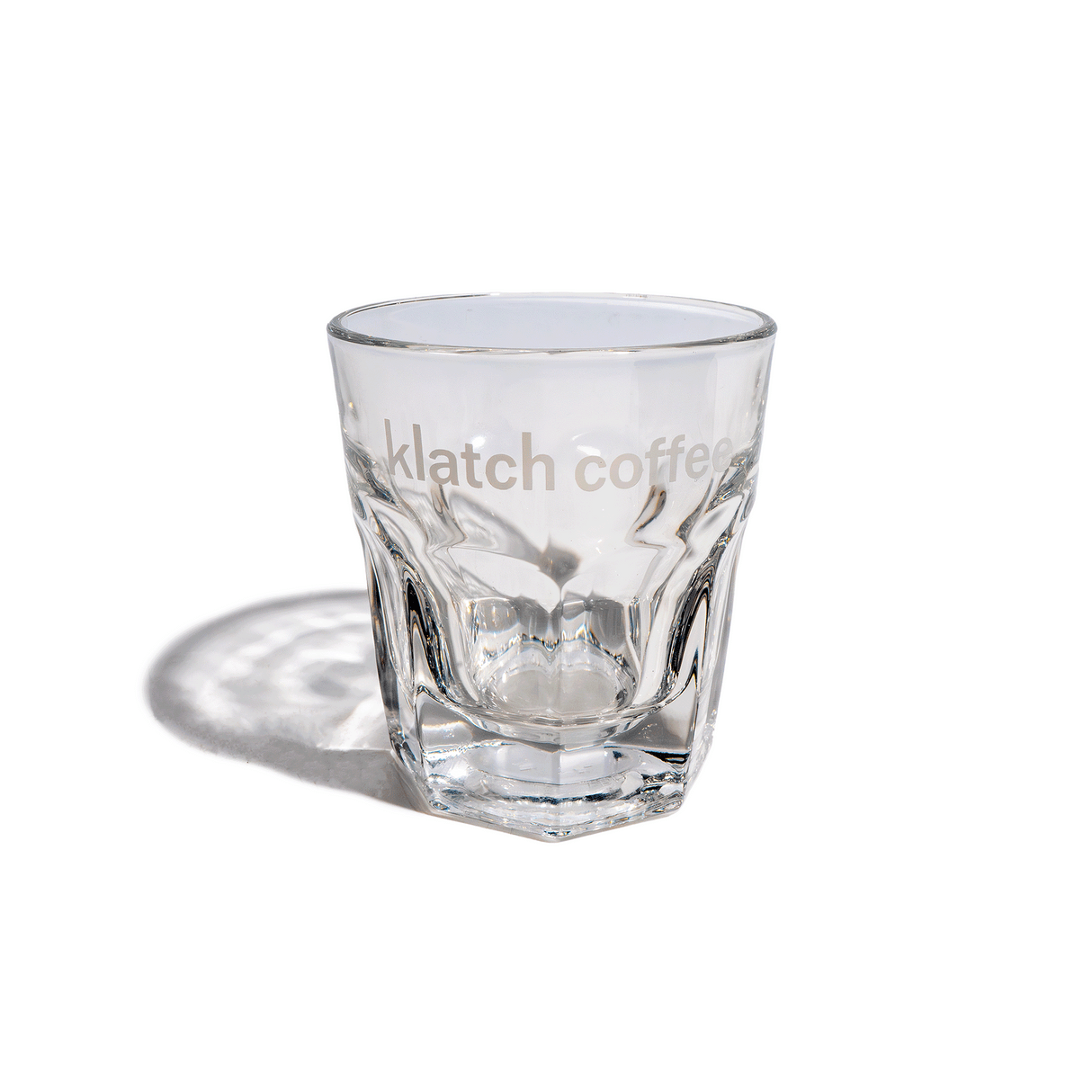 A clear Gibraltar Libbey glass with the Klatch Coffee logo, featuring a slightly flared top and architectural base.