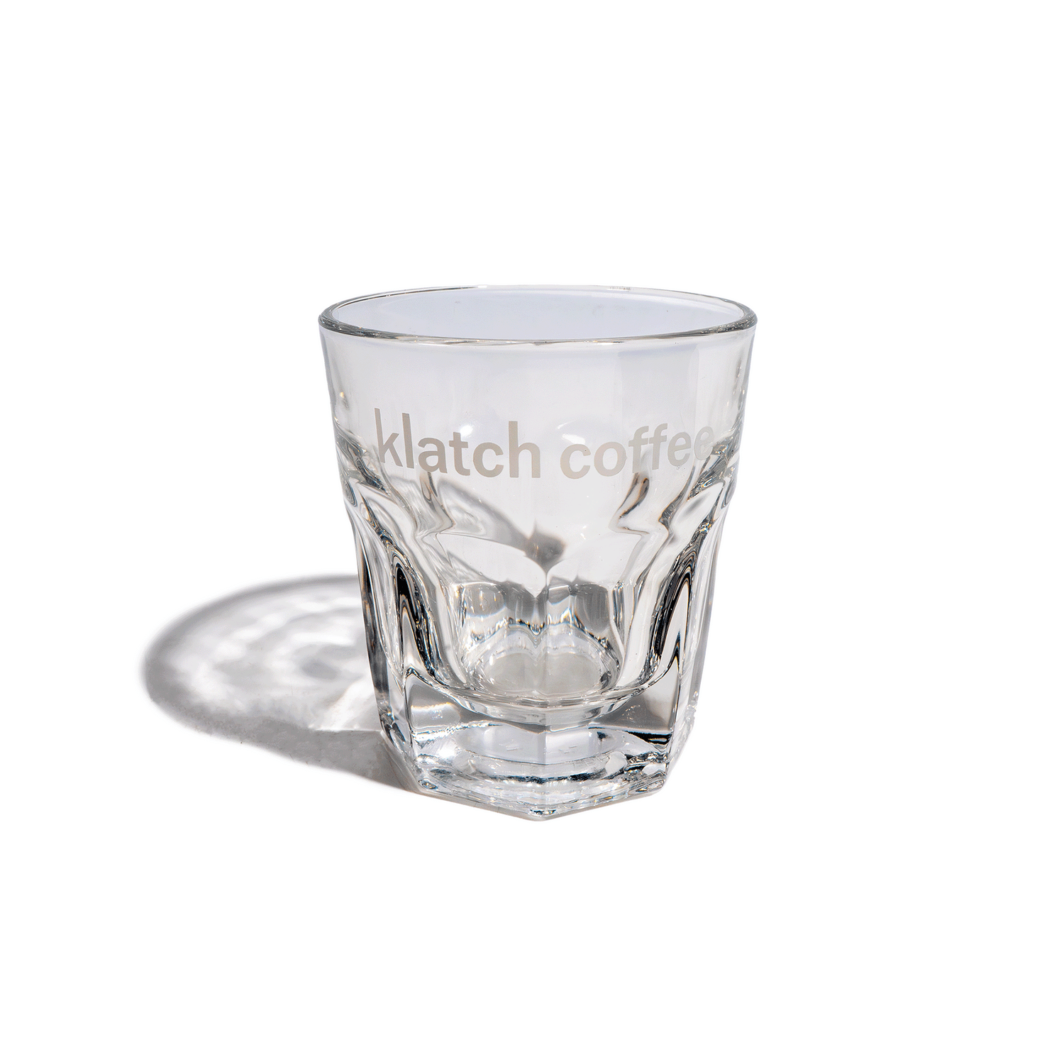 A clear Gibraltar Libbey glass with the Klatch Coffee logo, featuring a slightly flared top and architectural base.
