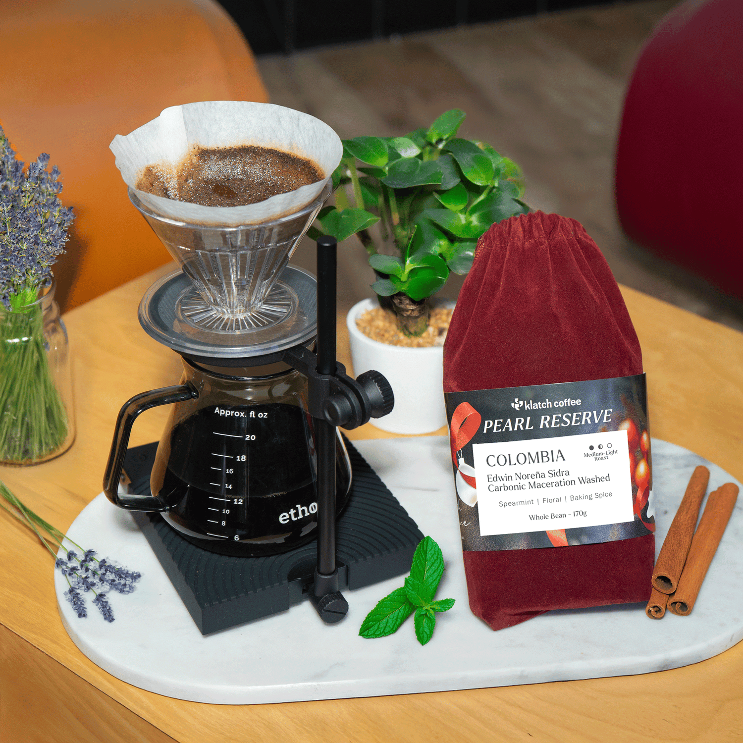 Coffee brewing setup with a coffee filter, coffee grinder, and a bag of coffee on a wooden table.