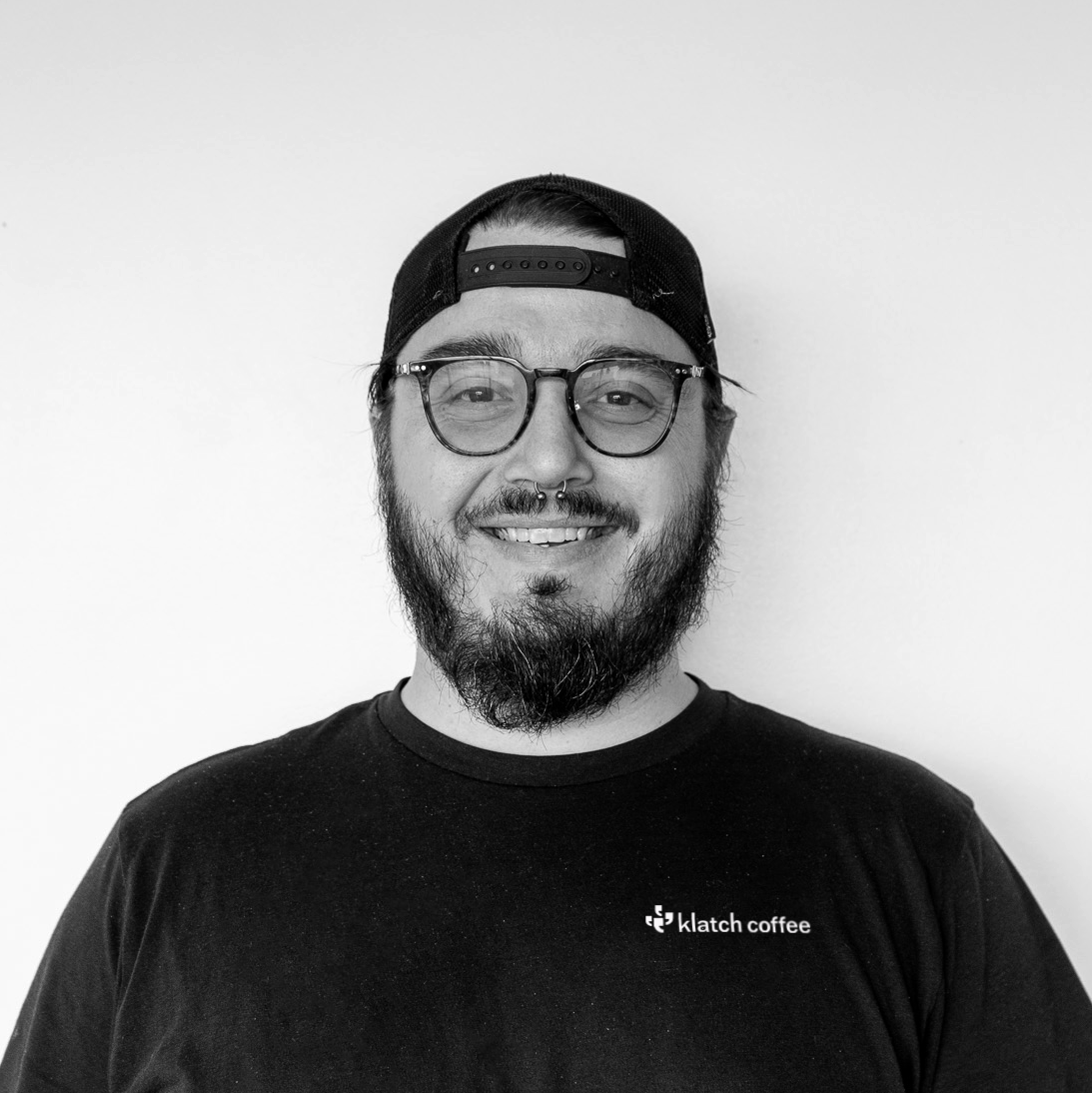 Black and white image of a Joshua Austin, Klatch Coffee's Facilities Care Manager.