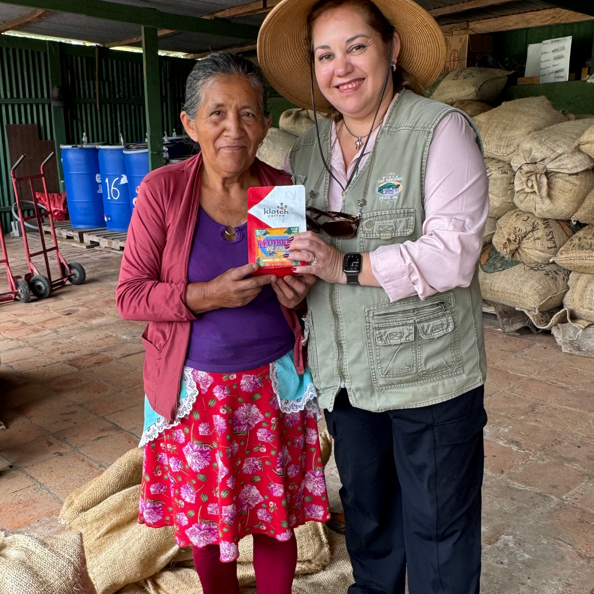 Lucia and women worker holding Mujeres De Cafe bag.