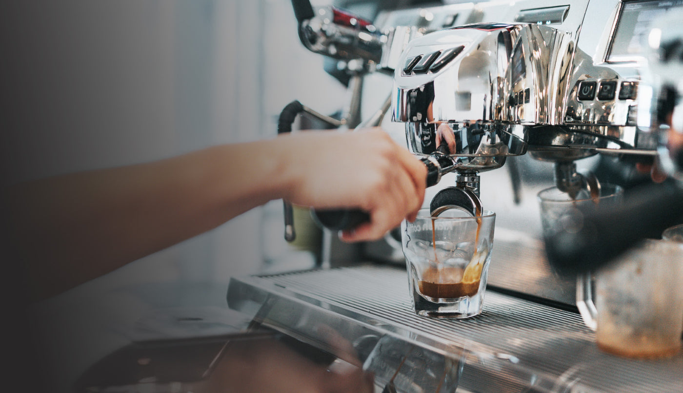 Pulling shots of espresso from an espresso machine.