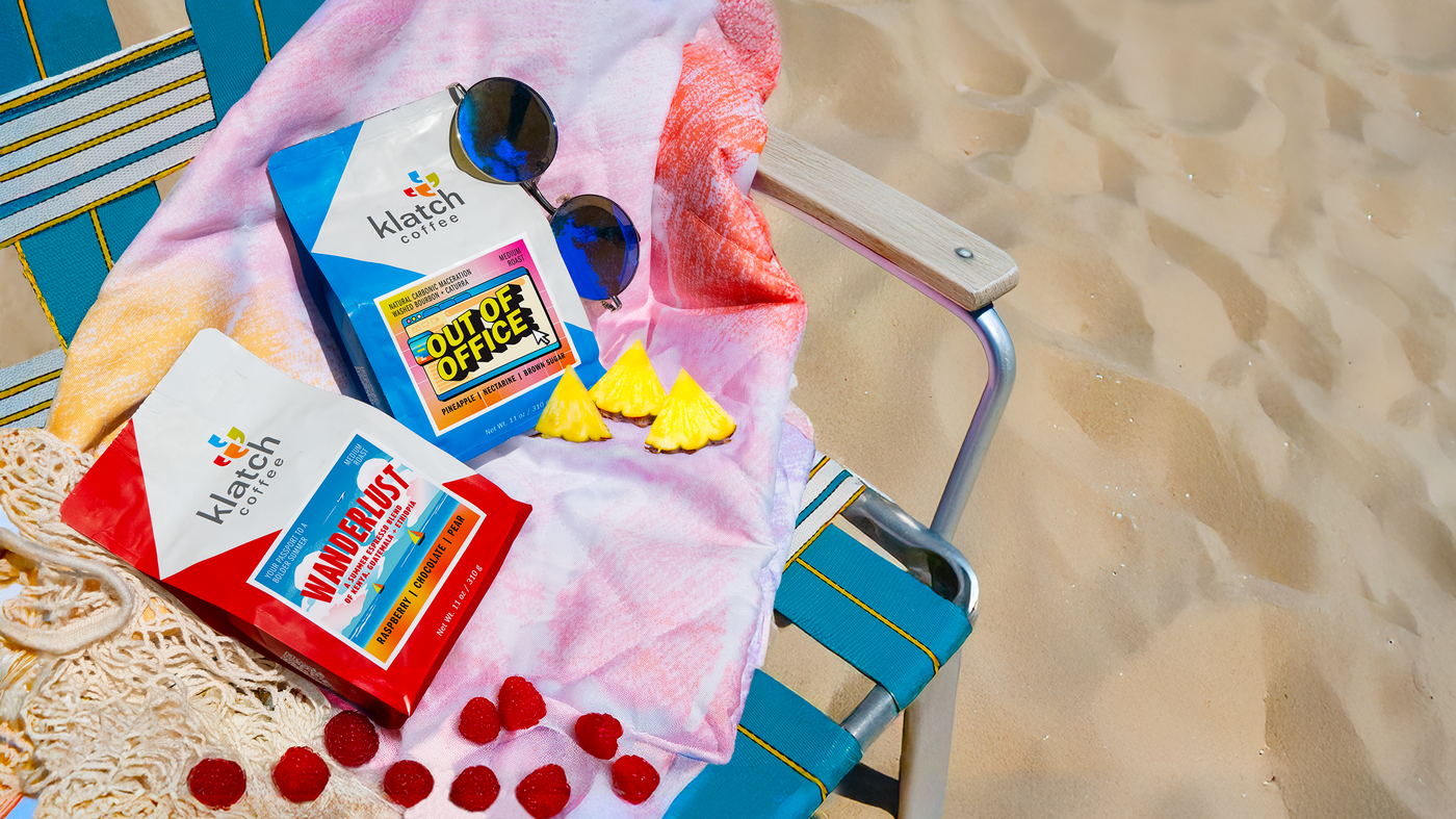 Klatch coffee summer coffees 'Out of Office and Wanderlust Espresso' on a beach chair with sand in the background