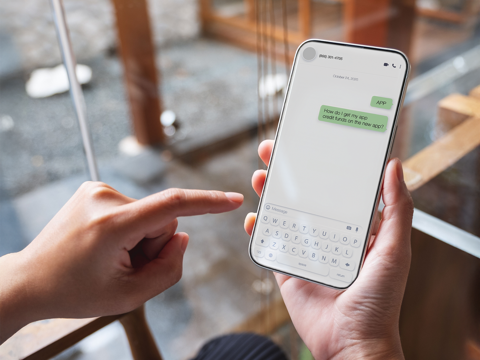 Close-up of a person holding a smartphone with a text messaging app open, showing the words ‘APP’ and ‘How do I get my app credit funds in the new app?’