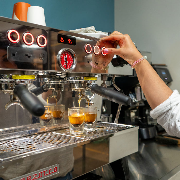 Pulling shots of espresso from an espresso machine.