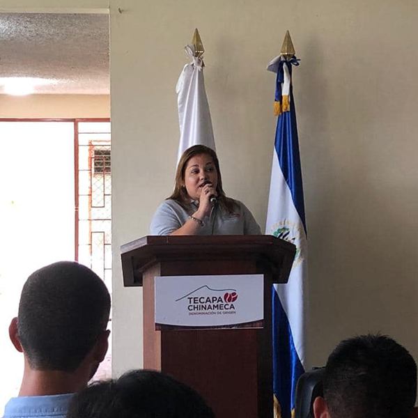 Producer Lucia Ortiz of Finca Las Mercedes making an acceptance  speech at a podium for her Tecapa Chinameca 1st Place Pacamara award.