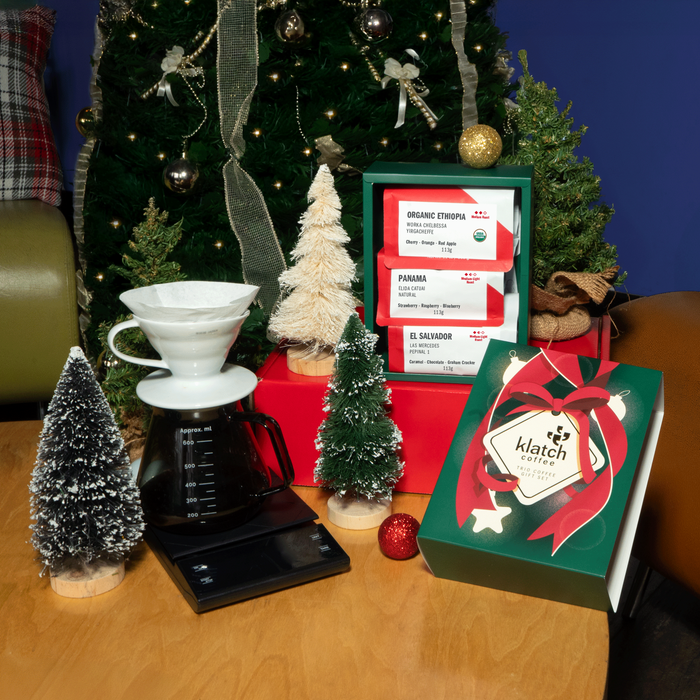 Classic holiday trio featuring Christmas trees, ornaments, and a brewer arranged together in a festive display.