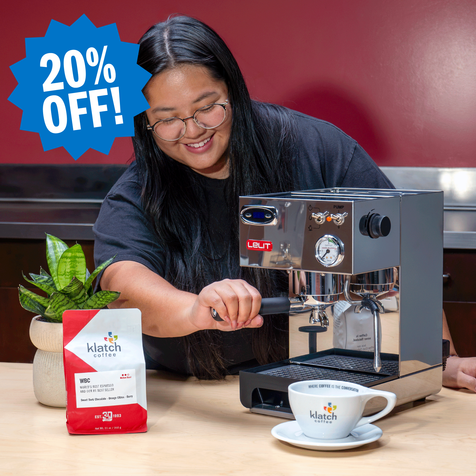 Woman using a LELIT espresso machine alongside a Klatch Coffee WBC espresso bag and cup, with a badge highlighting 20% off.