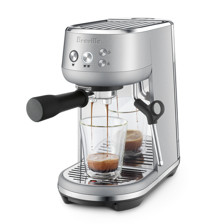 Breville Bambino Espresso Machine with two glasses of coffee on a white background