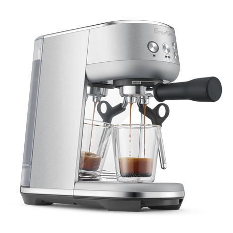 Breville Bambino Espresso Machine  with a glass cup of espresso on a white background
