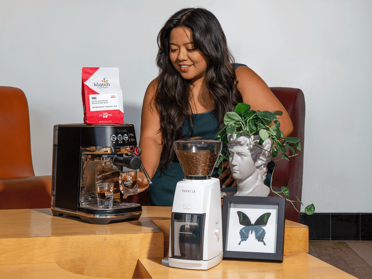 Woman preparing espresso with a Breville Bambino Plus espresso machine, Baratza grinder, and Klatch Coffee WBC Espresso.