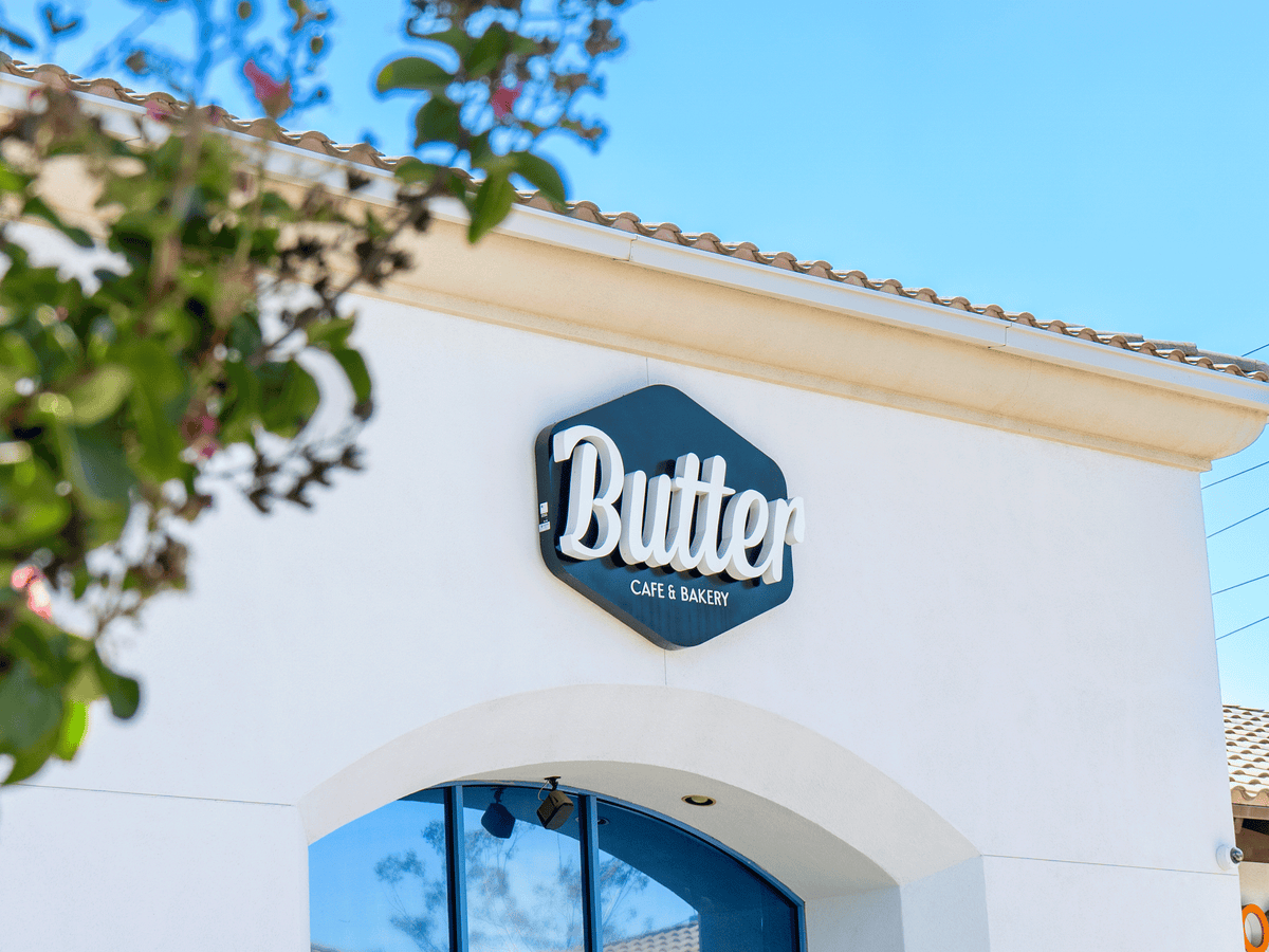 Exterior of Butter Café & Bakery with its sign displayed above the entrance on a sunny day.
