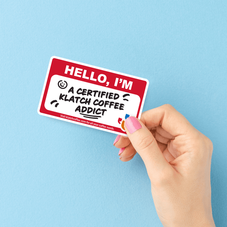 Hand holding a sticker with text on a blue background