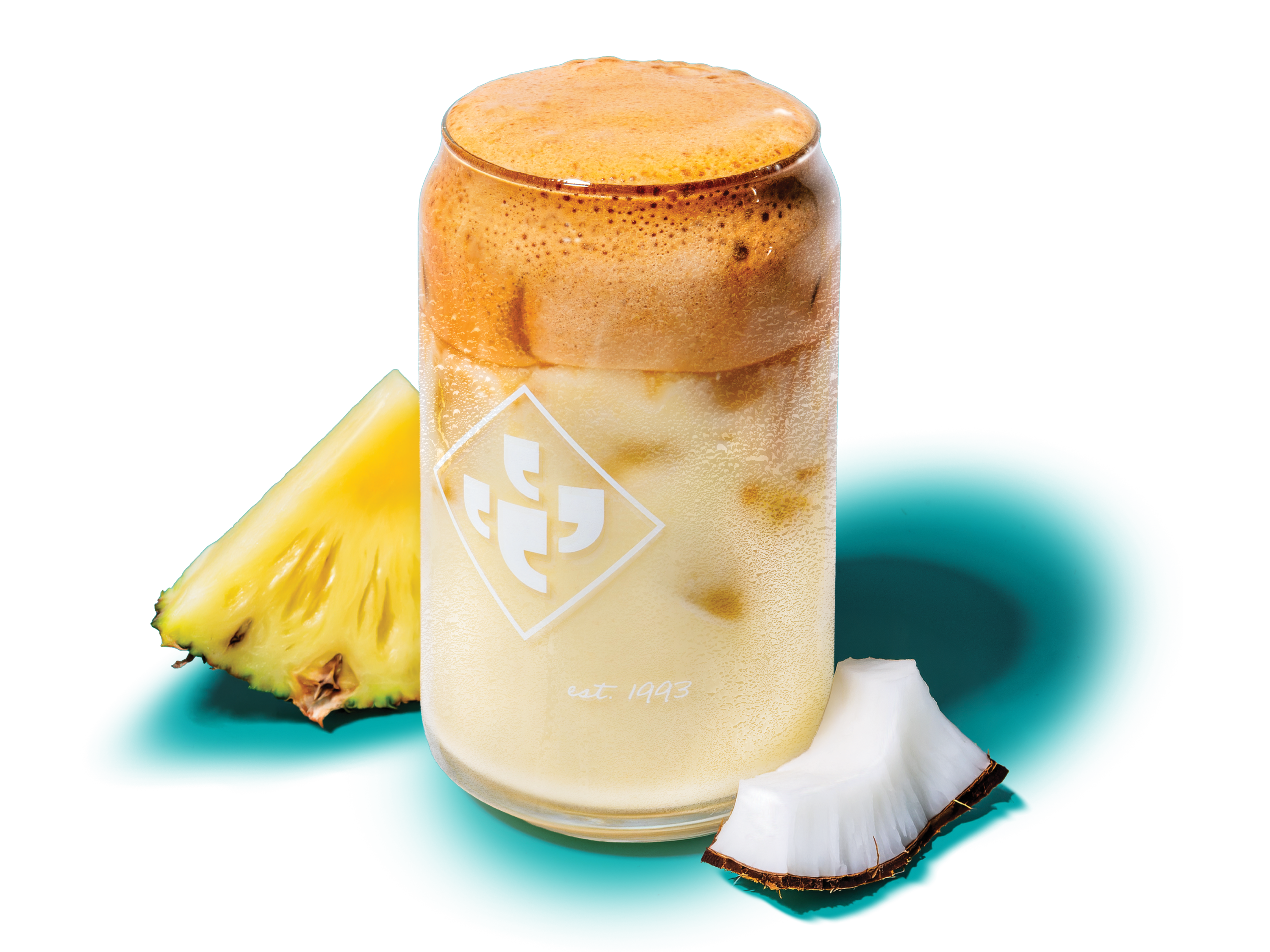 Klatch Coffee Whipped Piña Colada next to a pineapple slice and coconut on a transparent background.