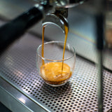Centennial espresso extraction into glass cup.