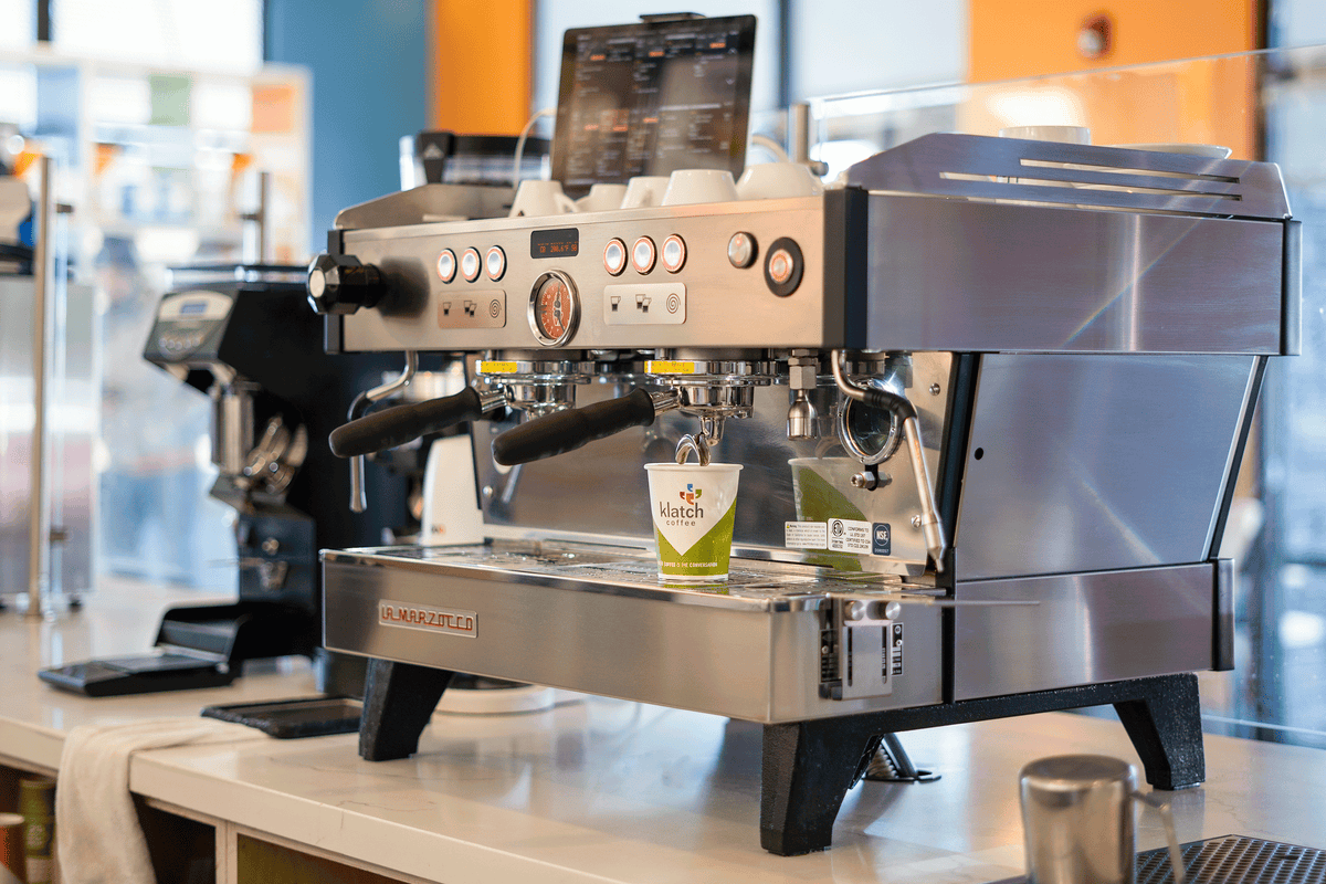 La Marzocco commercial espresso machine on a café counter with a Klatch Coffee cup positioned beneath the group head.