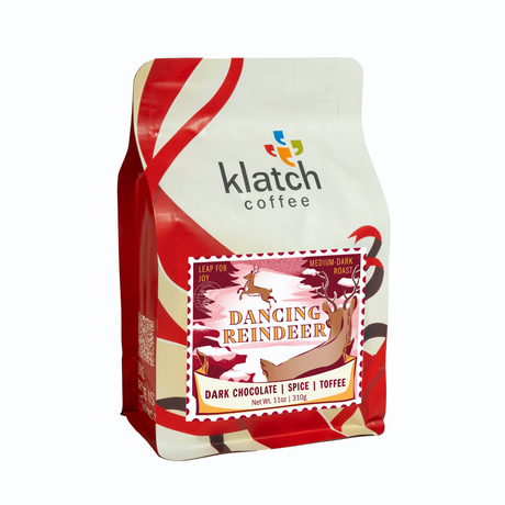 Holiday white and red ribbon graphics on Klatch Coffee 'Dancing Reindeer' bag on a white background.