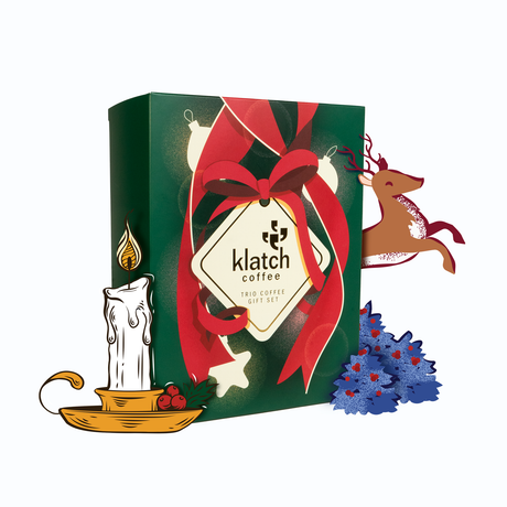 Gift set packaging with 'Klatch Coffee' branding featuring, Dancing Reindeer, Fireside, Original Christmas with decorative elements  a candle, Reindeer and coffee tree on a white background.