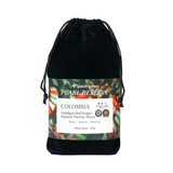 A black velvet drawstring pouch containing Klatch Coffee Pearl Reserve Colombia whole bean coffee, with a detailed product label wrapped around the middle, set against a plain white background.