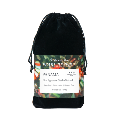 A black velvet drawstring pouch containing Klatch Coffee Pearl Reserve Panama whole bean coffee, with a detailed product label wrapped around the middle, set against a plain white background.