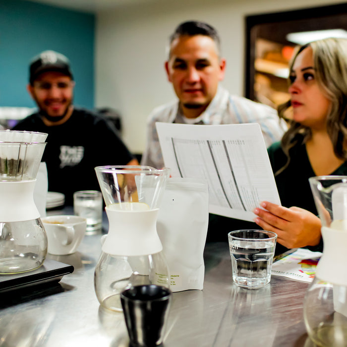 People looking at a list of coffee options.
