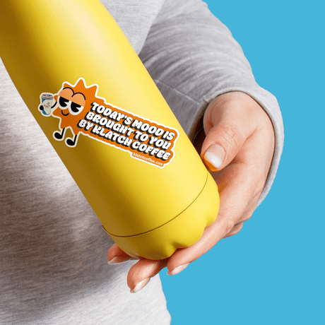 Yellow tumbler with a sticker on a blue background