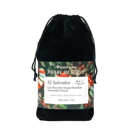 A black velvet drawstring pouch with a printed label for Pearl Reserve El Salvador coffee, shown on a plain white background.