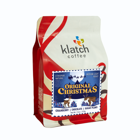Holiday white and red ribbon graphics on Klatch Coffee Original Christmas coffee bag on a white background.