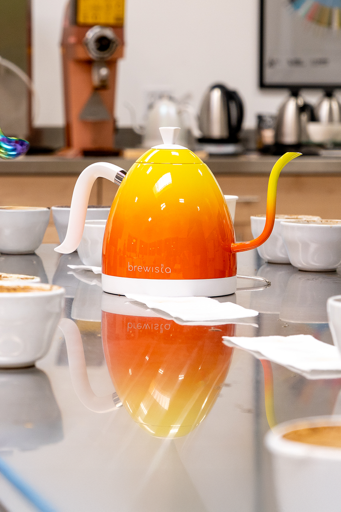 Colorful coffee maker on a reflective kitchen counter.
