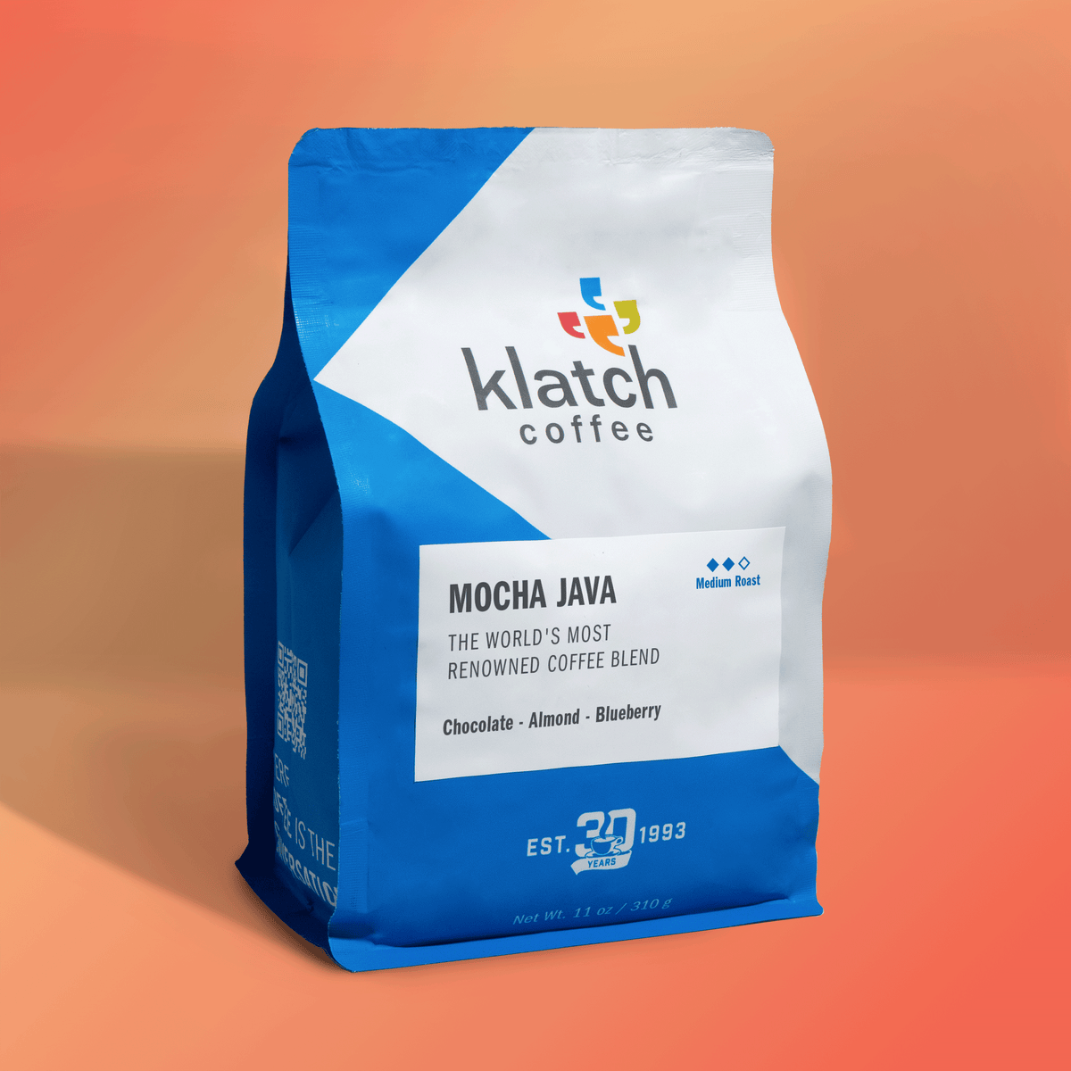 Bag of Klatch Coffee Mocha Java medium roast featuring notes of chocolate, almond, and blueberry against a warm orange background.