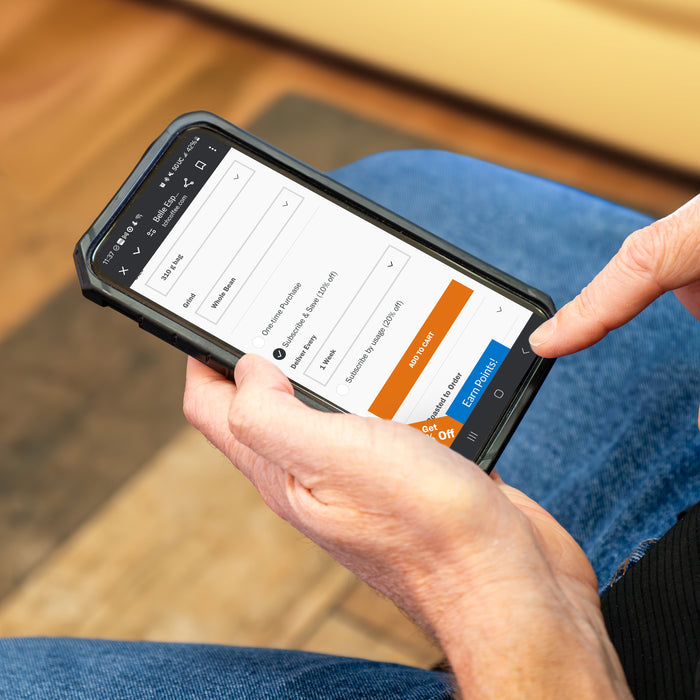 hand holding phone selecting "subscribe and save" option on the phone screen.